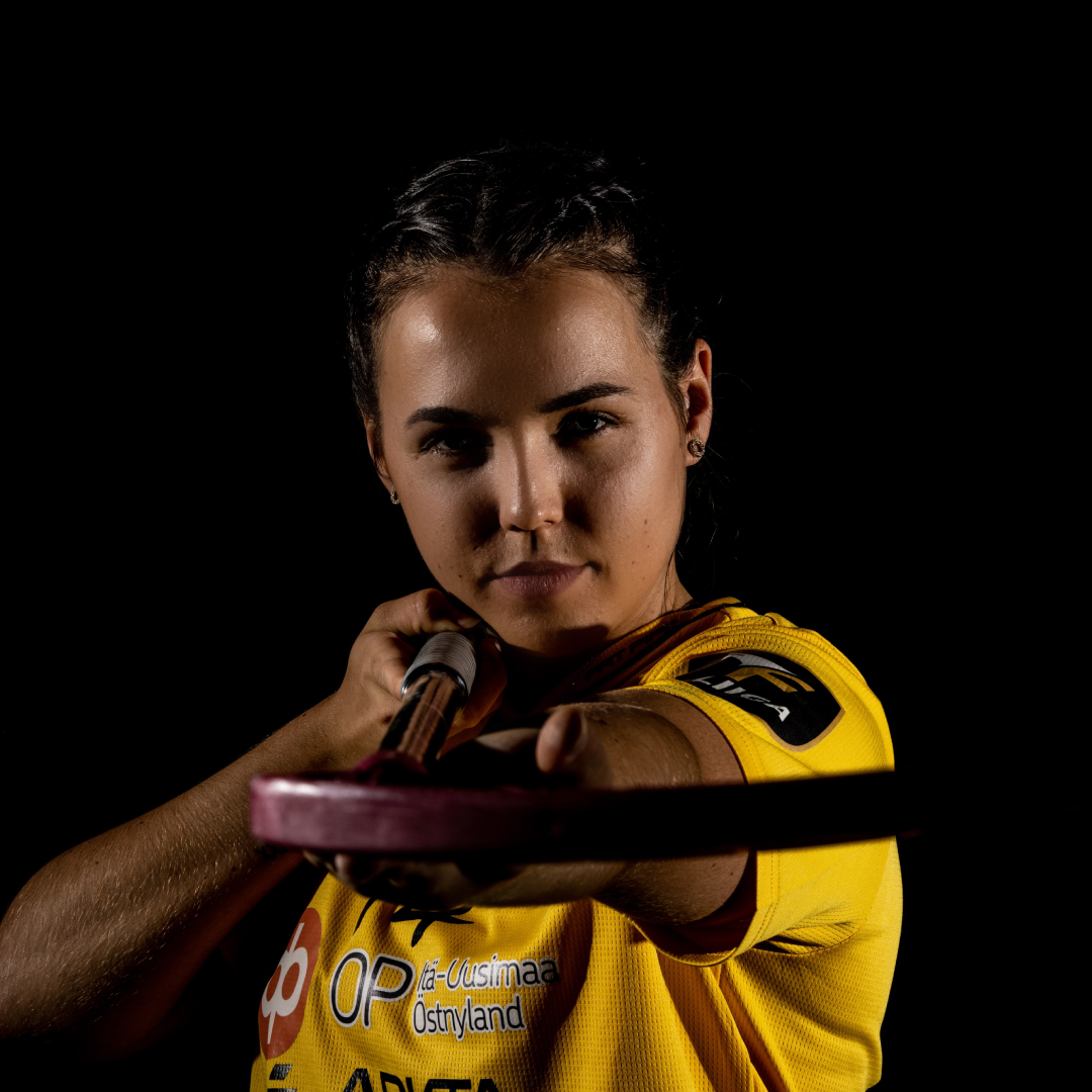 Fokusbild von Celine Stettler mit Unihockeystock Richtung Kamera gehalten mit schwarzem Hintergrund