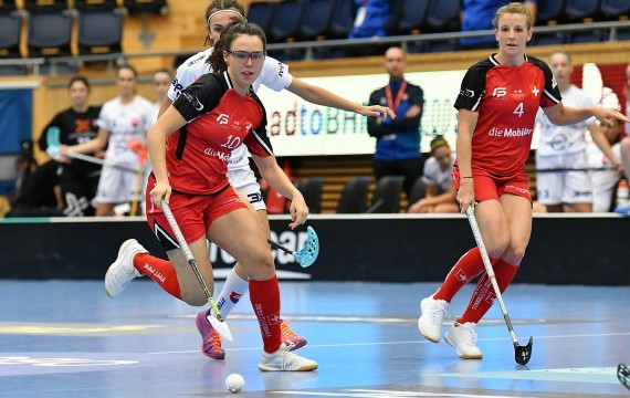 Céline Stettler en maillot rouge jouant avec le ballon au floorball