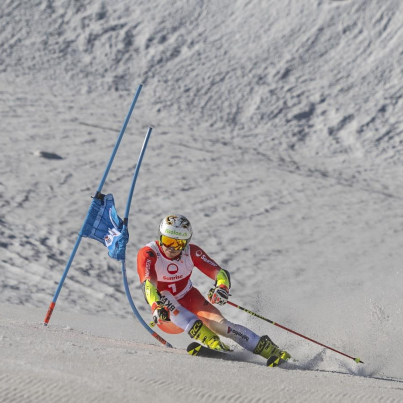 Noel von Grünigen bei der Abfahrt auf Ski neben einem Blauen Tor