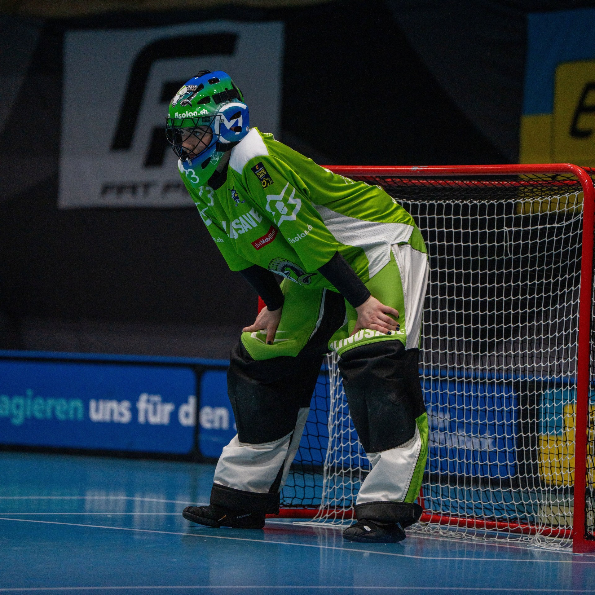 Martina Cerny en goal avec chemise verte et casque, debout dans le but.